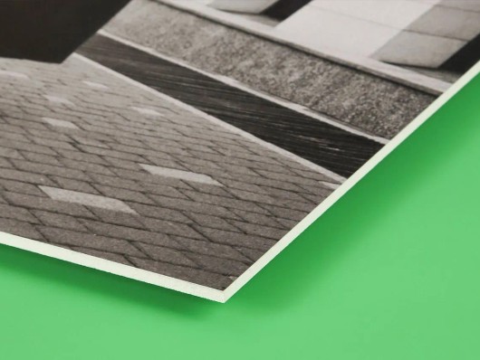 Dezelfde dorpsfoto op forex van opzij, met zicht op de dunne, vlakke plaat
