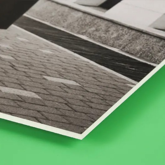 Dezelfde dorpsfoto op forex van opzij, met zicht op de dunne, vlakke plaat