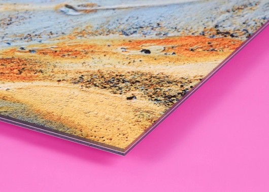 Zandfoto achter plexiglas, van opzij gezien